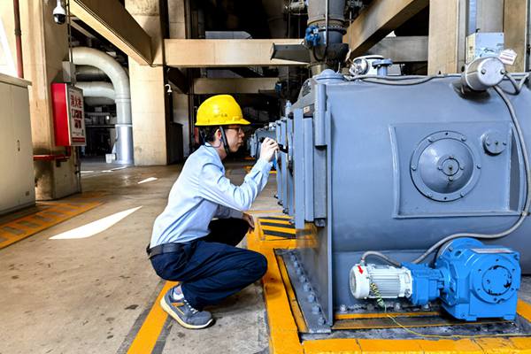 圖為運行人員巡視檢查給煤機(jī)清掃鏈條運行情況